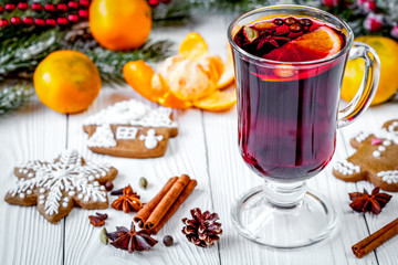 Christmas mulled wine with spices in cup on wooden background