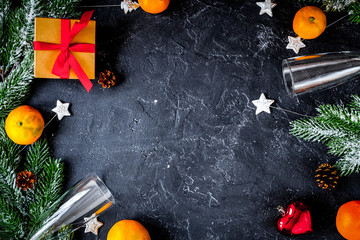 glasses and Christmas ornaments on dark background top view