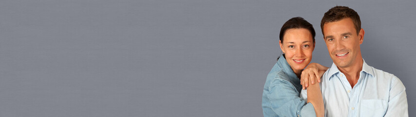 Happy couple standing on grey background- banner template web