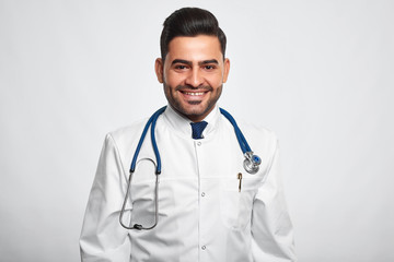 Fototapeta premium Studio shot of a happy handsome male doctor smiling cheerfully posing at studio copyspace happiness vitality health living profession occupation job success survey good news.