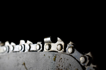 Close up of chainsaw blade isolated on black.