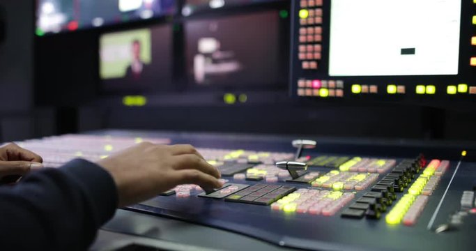 Close-up of hand operating TV control room technology