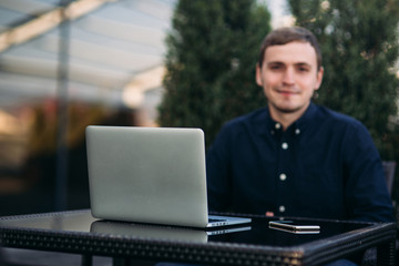 The young manager working on a laptop in the park. Lunch Break.