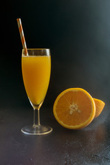 Freshly squeezed orange juice on a dark background.