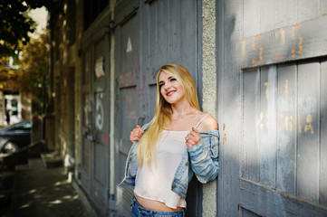 Obraz premium Blonde girl wear on jeans jacket posed at street.