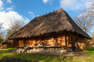 Plakat old wooden houses with thatched roof, Ancient traditional ukrainian rural cottage with a straw roof
