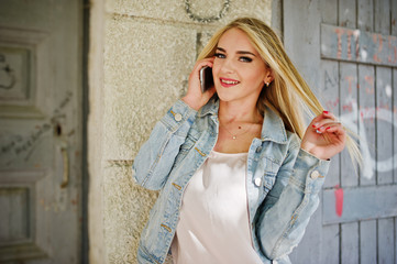 Blonde girl wear on jeans jacket posed at street.