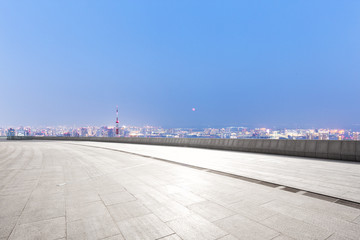 empty marble floor with modern cityscape at twilight