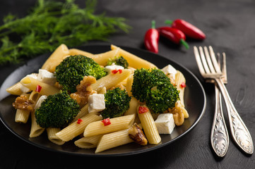 Pasta penne with broccoli, feta cheese and pepper.