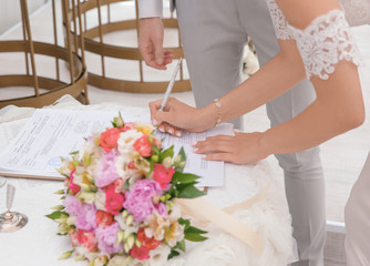 Bride signing marriage certificate, closeup
