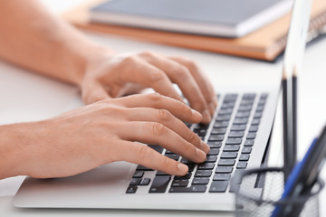 Fototapeta na wymiar Male hands on laptop keyboard, closeup
