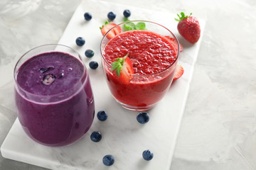 Glasses with different smoothies on stone board