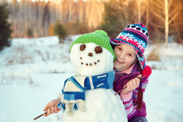 happy kid playing with snowman