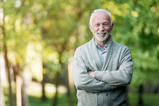Elderly man smiling outdoors in nature 