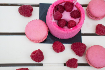 Rasperry charlotte,macaroons , raspberry berries on a tray of white boards