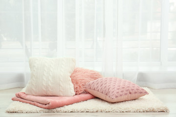 Fototapeta na wymiar Colorful pillows on floor indoors