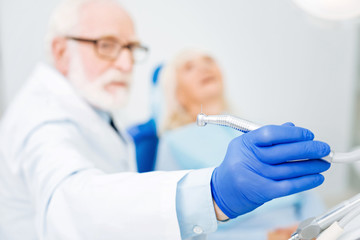 High quality. Close up of professional dental tool in hand of skilled doctor being concentrated on working