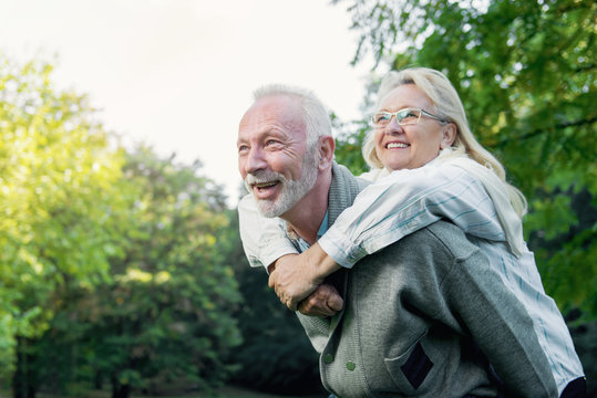 Happy senior couple smiling outdoors in nature, having fun  