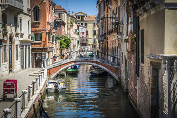 Obraz na płótnie Canvas Canals and historic buildings of Venice, Italy. Narrow canals, old houses, reflection on water on a summer day in Venice, Italy.