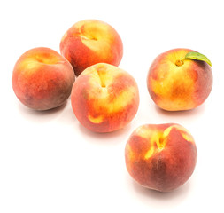 Fototapeta na wymiar Ripe whole peaches, one with green leaf, isolated on white background.