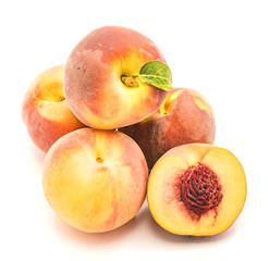 Folded peaches, one with green leaf and one sliced half with a stone, isolated on white background.