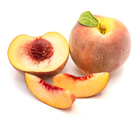 One whole one half with a stone and two peach slices, isolated on white background.
