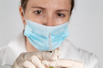 Close up of a female doctor or nurse preparing an injection or vaccine