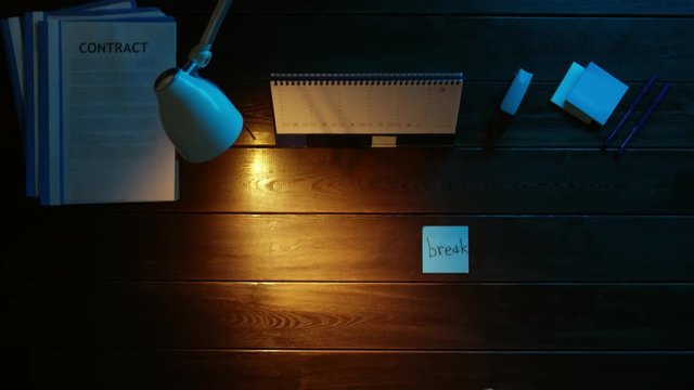 A man is sitting at an office desk and using a phone.