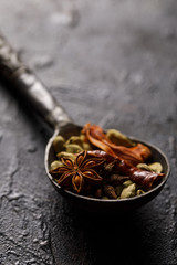 Indian Spices in a vintage spoon. On a black background.