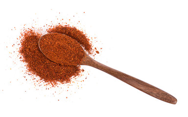 Pile of red paprika powder on spoon wooden
