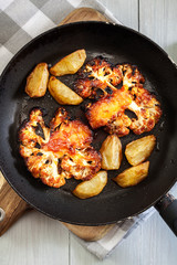 Vegetarian roasted cauliflower steak with herbsand fried potatoes