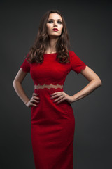 Fototapeta premium Pretty young sexy model female with dark hair in amazing red dress