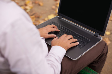 Businessman typing on laptop outdoor