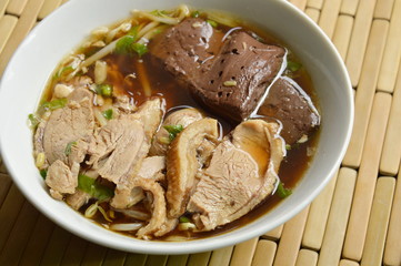 boiled duck meat and blood in brown Chinese herb soup on bowl