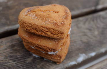Homemade cookies with sugar and cinnamon in the form of hearts on a wooden background