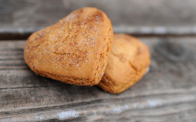 Homemade cookies with sugar and cinnamon in the form of hearts on a wooden background