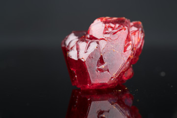 Red natural crystal mineral on a black background