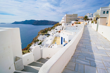 Fototapeta premium Oia miasteczko na Santorini wyspie, Grecja. Tradycyjne i słynne białe i różowe domy w słoneczny dzień
