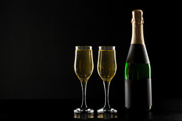 champagne wine glass and bottle on black background