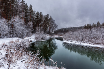 A cooling river with the first snow on the shore