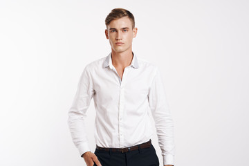 Fototapeta premium young man in a white shirt with a hand in his pocket