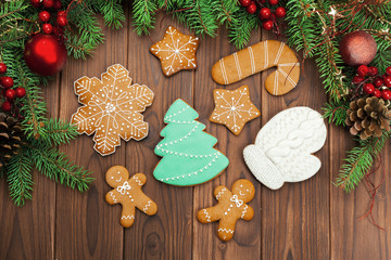 Christmas background with branch of fir tree decorated by gingerbread.