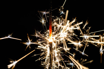 Fototapeta premium Burning sparkler isolated on black background blur
