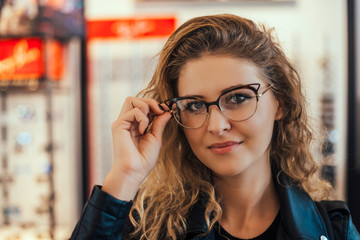 Portrait of young blonde woman in optical store.