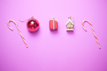 Christmas decorations with candy canes on pink background