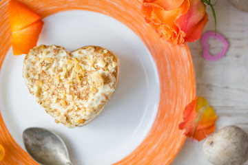 Cake in form of heart on plate.