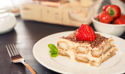 Homemade tiramisu cake decorated with strawberries Italian cuisine, Selective focus