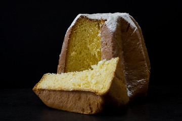 Pandoro Christmas cake with sugar on black background