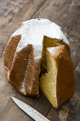 Pandoro Christmas cake with sugar on wooden table