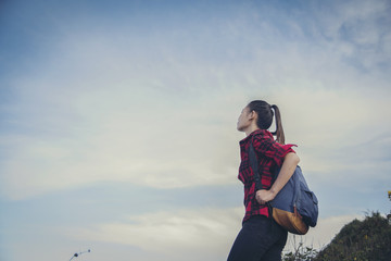Hipster young girl with backpack enjoying sunset on peak of foggy mountain. Tourist traveler on background view mockup. Hiker looking sunlight in trip